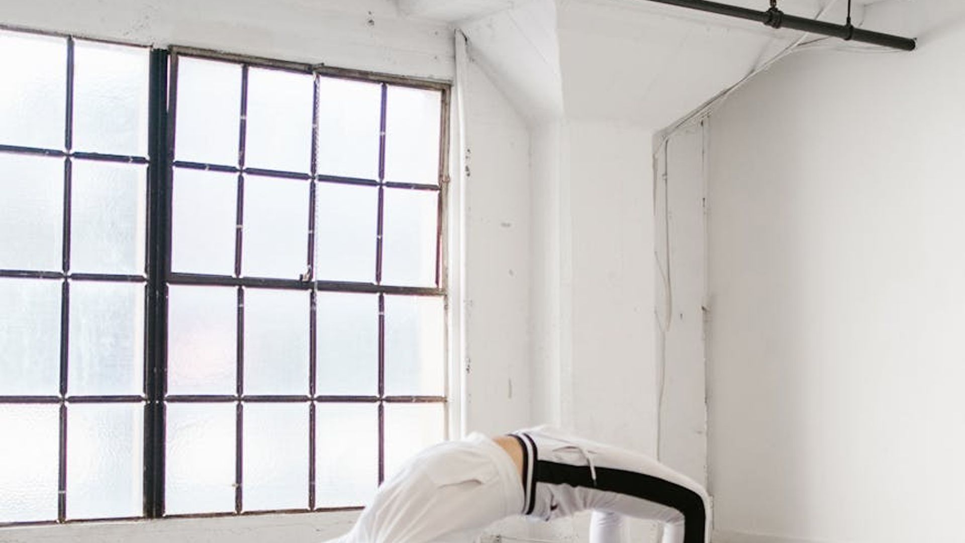 Person practicing yoga in a bright minimal studio space